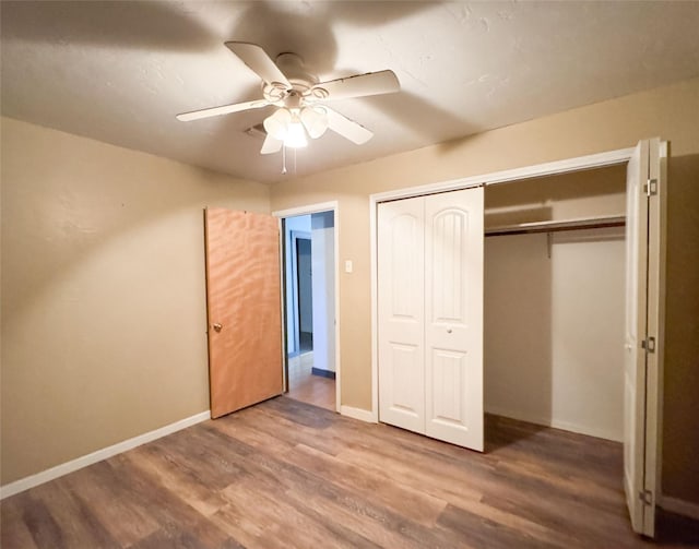 unfurnished bedroom with hardwood / wood-style flooring, ceiling fan, and a closet