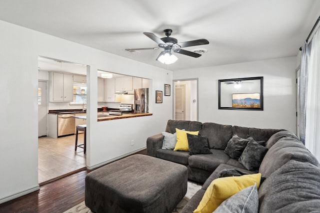 living room featuring ceiling fan and light hardwood / wood-style floors