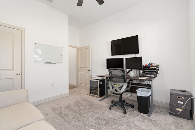 carpeted office space with ceiling fan