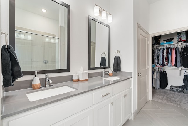 bathroom with a shower with door, vanity, and tile patterned flooring