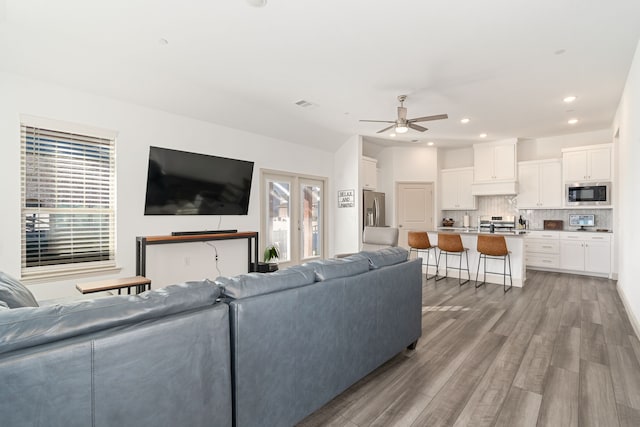 living room with light hardwood / wood-style floors and ceiling fan