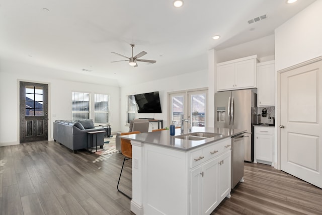 kitchen with sink, an island with sink, white cabinets, and appliances with stainless steel finishes