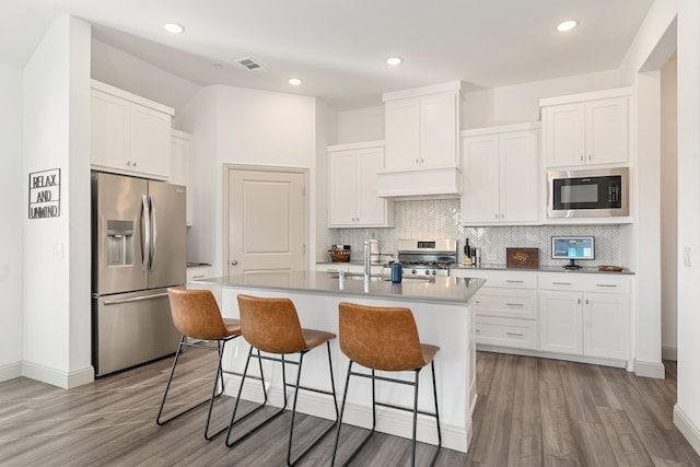 kitchen featuring appliances with stainless steel finishes, sink, a kitchen island with sink, and white cabinets