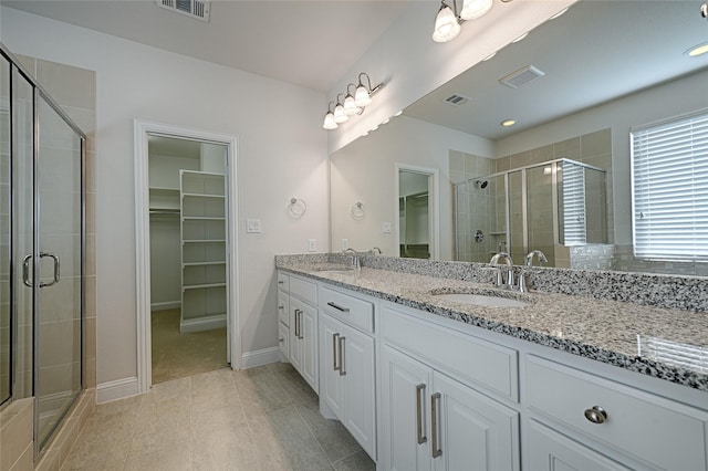 bathroom with tile patterned flooring, vanity, and an enclosed shower