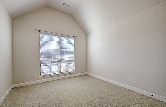 spare room with carpet floors and vaulted ceiling