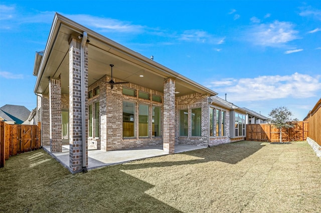 rear view of property featuring a patio area and a lawn