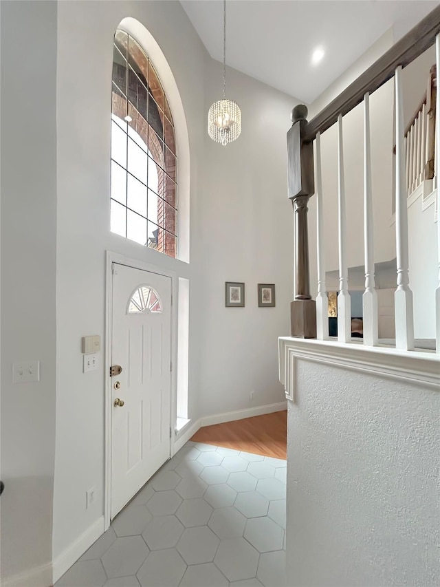 foyer with tile patterned floors and an inviting chandelier