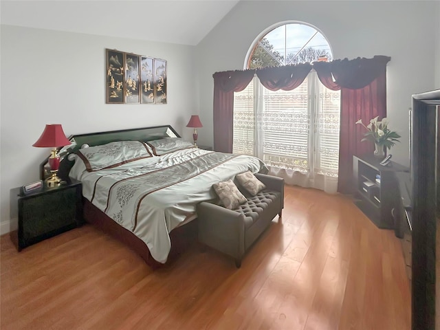 bedroom with hardwood / wood-style flooring and lofted ceiling