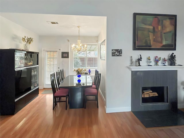 dining room with hardwood / wood-style floors and a chandelier