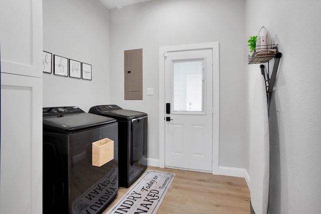 laundry area featuring independent washer and dryer, electric panel, and light hardwood / wood-style floors