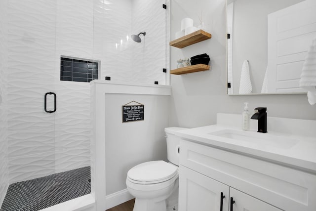 bathroom with a shower with shower door, toilet, and vanity