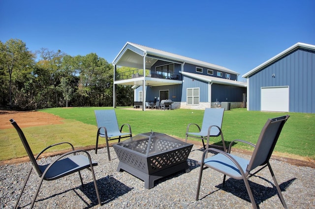 exterior space featuring a balcony, a garage, and an outdoor fire pit