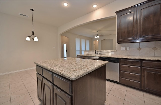 kitchen with pendant lighting, a center island, stainless steel dishwasher, light tile patterned floors, and dark brown cabinets