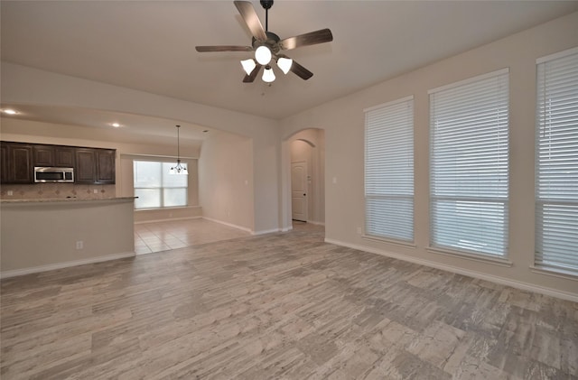 unfurnished living room with light tile patterned floors and ceiling fan