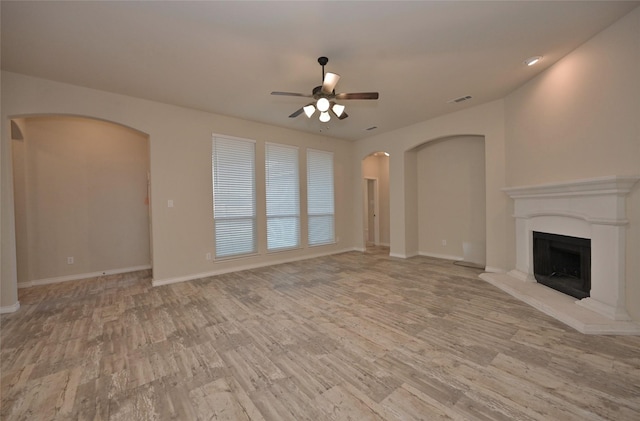 unfurnished living room with light wood-type flooring and ceiling fan