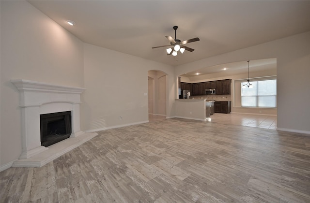 unfurnished living room with ceiling fan and light hardwood / wood-style floors