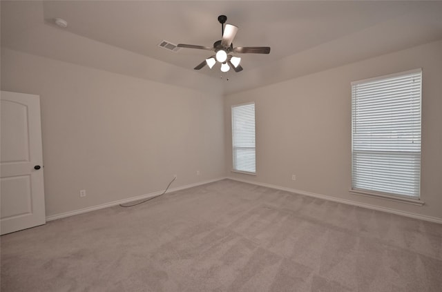 empty room with ceiling fan, light colored carpet, and vaulted ceiling