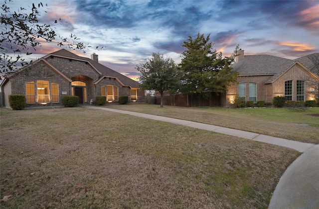 french country inspired facade with a yard