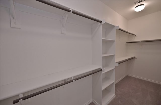 spacious closet featuring dark carpet