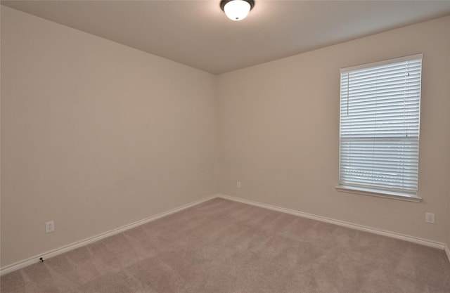 spare room featuring light colored carpet