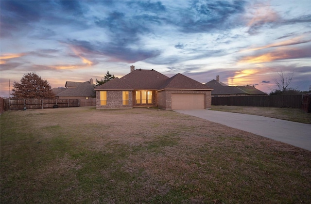 view of front of property with a garage and a lawn