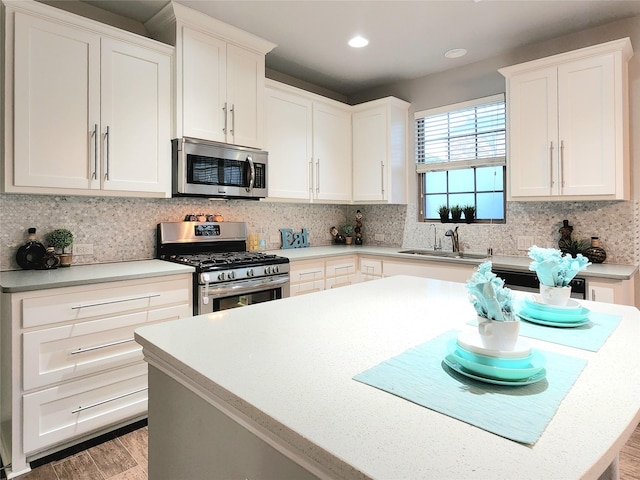 kitchen with sink, white cabinetry, decorative backsplash, and stainless steel appliances