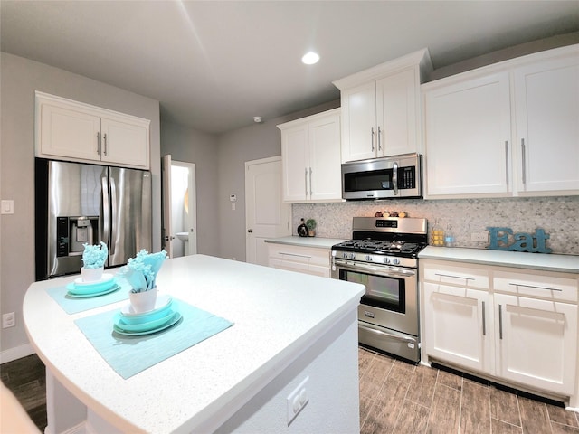 kitchen with white cabinetry, stainless steel appliances, and tasteful backsplash