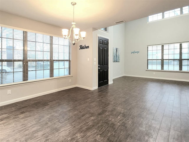 unfurnished room featuring plenty of natural light and dark hardwood / wood-style flooring