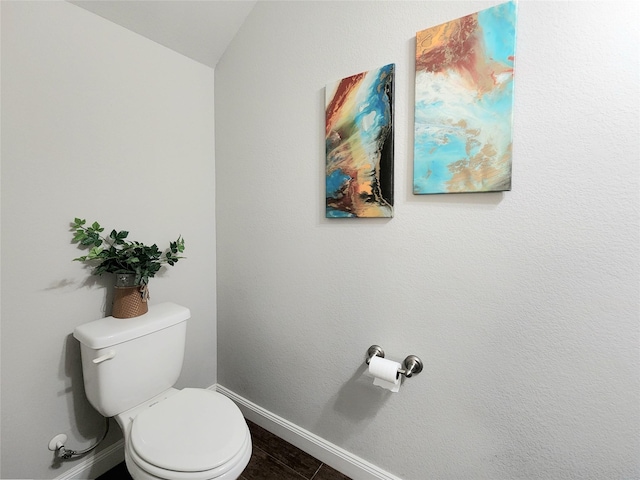 bathroom featuring toilet, lofted ceiling, and tile patterned flooring