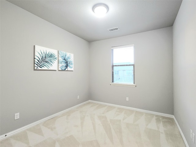 unfurnished room featuring light carpet