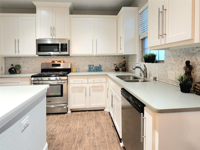 kitchen featuring sink, backsplash, white cabinets, and appliances with stainless steel finishes