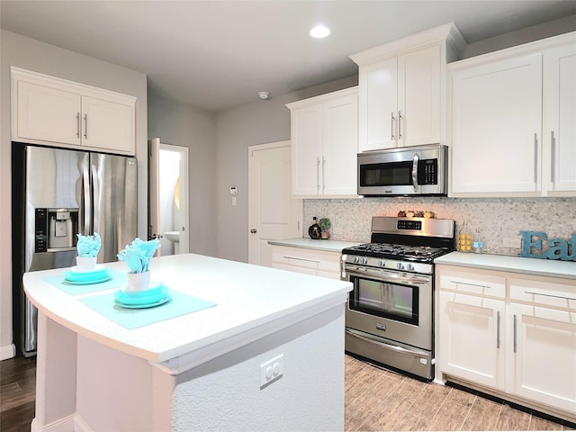 kitchen with a center island, light hardwood / wood-style floors, white cabinetry, backsplash, and stainless steel appliances