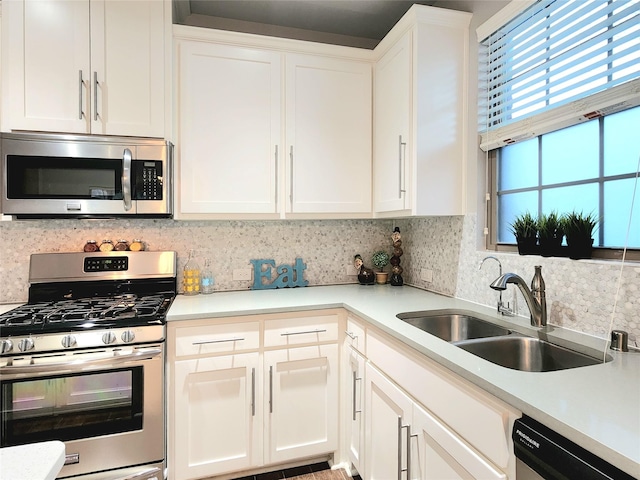 kitchen with sink, white cabinets, decorative backsplash, and stainless steel appliances