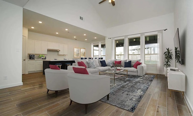 living room with ceiling fan and high vaulted ceiling