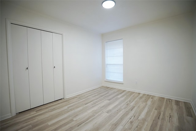 unfurnished bedroom with light hardwood / wood-style floors and a closet