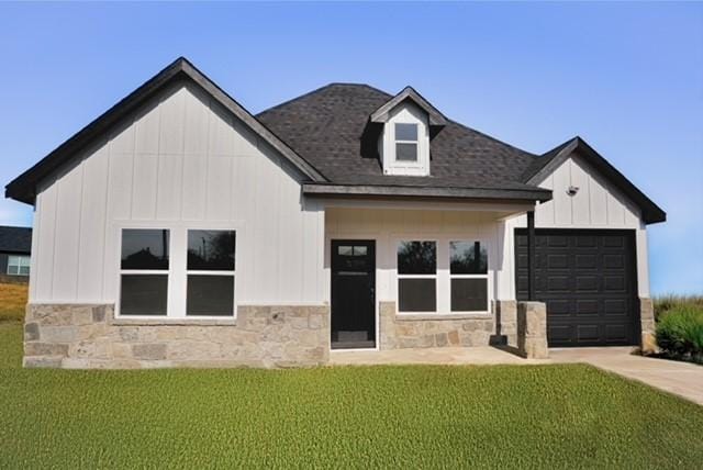 back of house with a garage and a yard