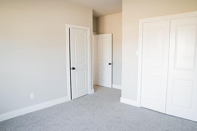 unfurnished bedroom with light carpet and a closet