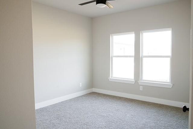 carpeted spare room featuring ceiling fan