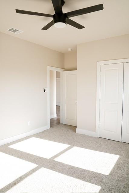 unfurnished bedroom featuring a closet, ceiling fan, and carpet