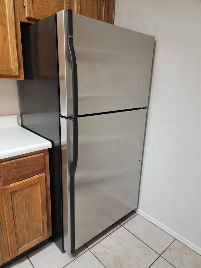 kitchen featuring light tile patterned floors and stainless steel refrigerator