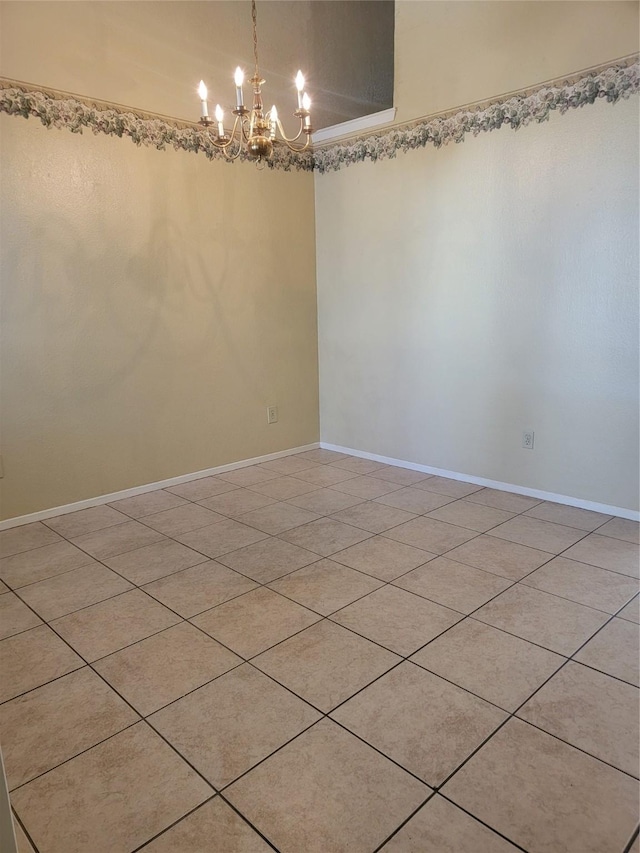 tiled empty room featuring a chandelier