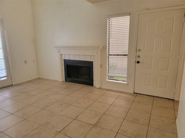 unfurnished living room with light tile patterned floors and a fireplace