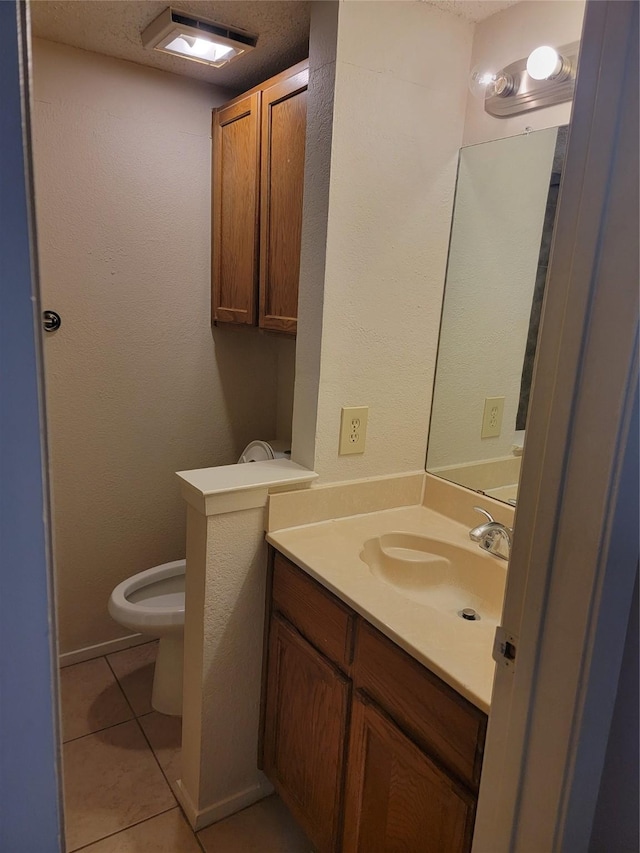 bathroom featuring vanity, tile patterned floors, and toilet