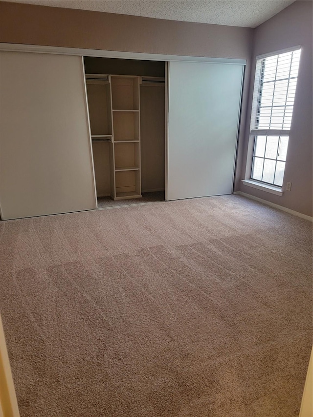 unfurnished bedroom with a closet, carpet flooring, and a textured ceiling