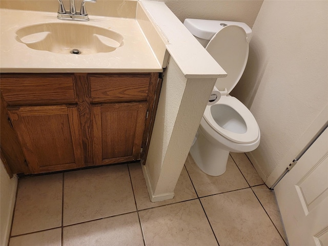 bathroom with tile patterned flooring, vanity, and toilet