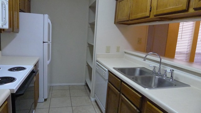 kitchen with white appliances, sink, and light tile patterned floors