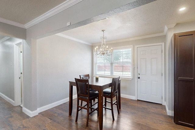 dining space featuring dark wood-type flooring, ornamental molding, and a textured ceiling