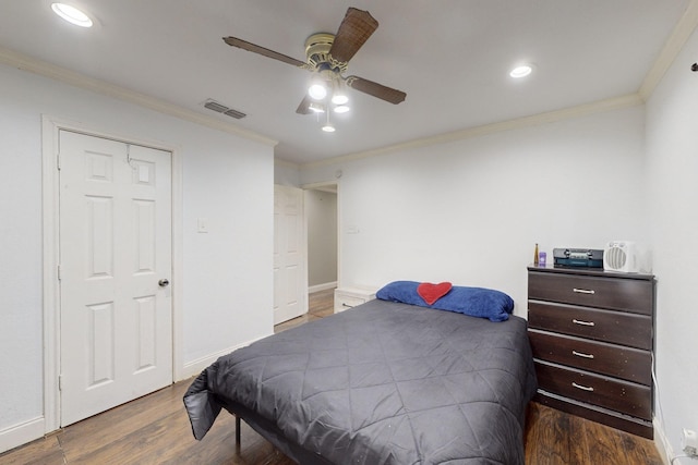 bedroom with ornamental molding, dark hardwood / wood-style floors, ceiling fan, and a closet