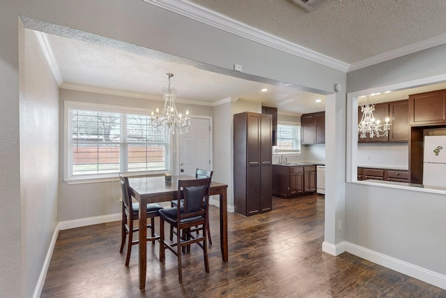 dining room featuring dark hardwood / wood-style flooring, a notable chandelier, ornamental molding, and a textured ceiling