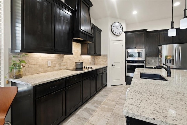 kitchen featuring sink, appliances with stainless steel finishes, hanging light fixtures, tasteful backsplash, and light stone countertops